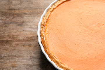 Fresh delicious homemade pumpkin pie on wooden background. Space for text