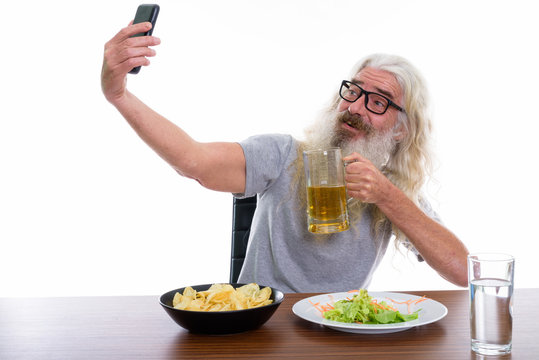 Happy senior bearded man smiling while taking selfie picture wit - Powered by Adobe