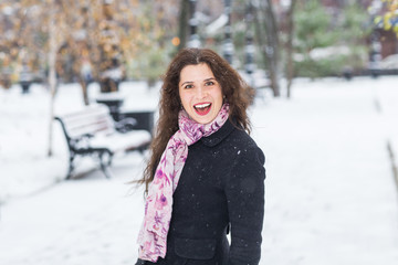 Season, people and emotions concept - young charming woman enjoy the snowy winter