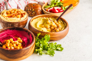 Different hummus bowls. Chickpea hummus, avocado hummus and beetroot hummus.