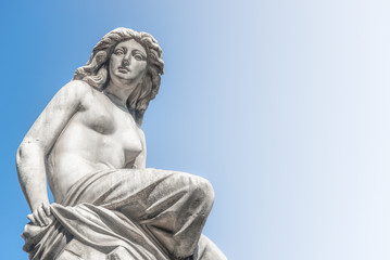 Fototapeta na wymiar Beautiful topless girl as summit of State Opera fountain in Vienna in front of blue sky, Austria, details, closeup