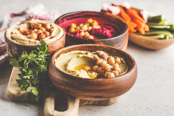 Different hummus bowls. Chickpea hummus, avocado hummus and beetroot hummus.