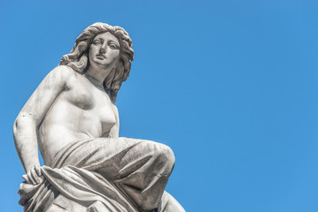 Beautiful topless girl as summit of State Opera fountain in Vienna in front of blue sky, Austria, details, closeup