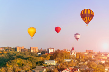 Amazing city background -  colorful hot air balloons flies glowing sunset