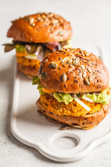 Vegan sweet potato (or pumpkin) burgers on white background.
