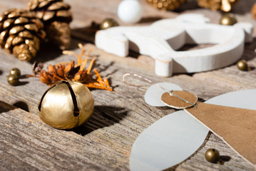 handmade paper angel and other Christmas ornaments on weathered old wooden table, with shades