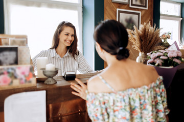 Beautiful brunette girl  at the counter in the flower shop