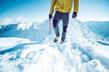 Gordijnen Een klimmer die in de winter een berg beklimt © kbarzycki