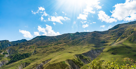 Mountain hill path road panoramic landscape, clouds in the blue sky, summer sunny day