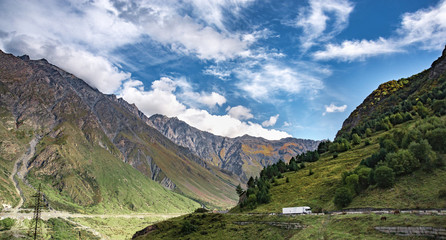 Mountain hill path road panoramic landscape, clouds in the blue sky