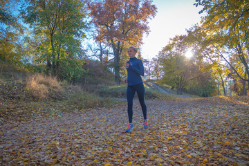 Fototapeta premium Beautiful sporty woman does sport exersices in the park, outdoors, soft focus background
