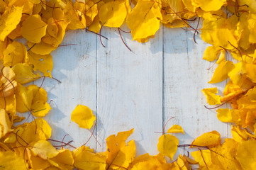 Empty white desk with nice frame from colourful yellow leaves, top-down shot of workspace with copy space