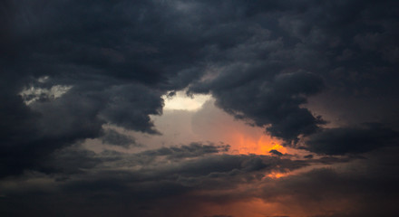 Fototapeta na wymiar Dramatic dark rain storm clouds sky at sunset bad weather thunderstorm summer storm
