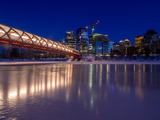 Calgary skyline in winter provides a backdrop to the frozen Bow River.