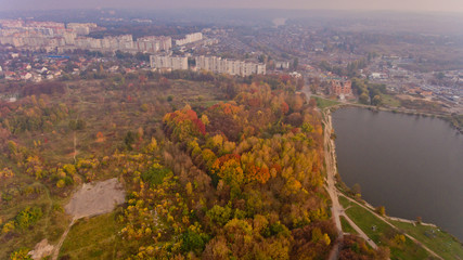 Aerial view of the autumn city park near the lake. Beautiful view of nature.