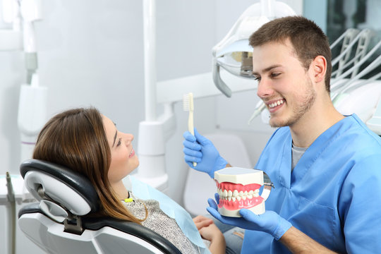 Dentist explaining teeth brushing procedure to a patient