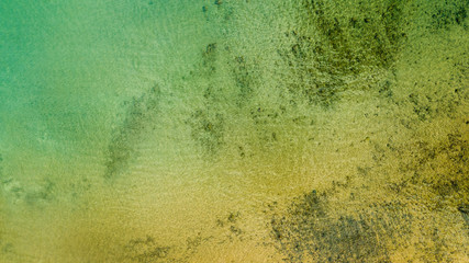 drone top view of yellow sand under ocean