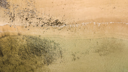 drone top view of yellow sand and water