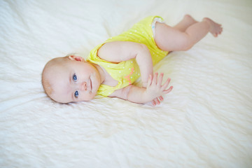 Adorable baby girl lying on bed