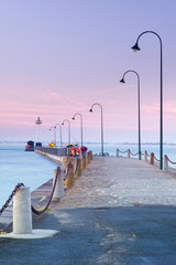 pink sunset above pier with street lighters