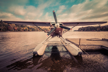 Seaplane docked at the shore in Long Lake, NY, awaiting leaf-peepers and adventure seekers, retro split tone