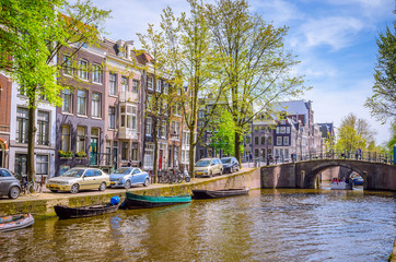 Fototapeta premium Tradycyjne stare budynki i łodzie w Amsterdamie, Holandia. Kanały Amsterdamu.