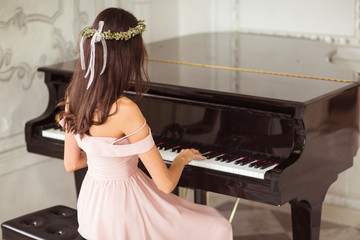 Woman playing piano in beautiful interiors.