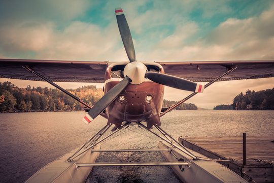 Fototapeta Seaplane docked at the shore in Long Lake, NY, awaiting leaf-peepers and adventure seekers, retro split tone