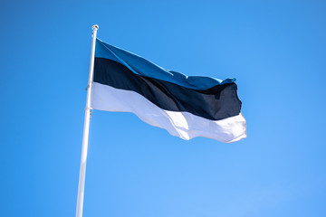 Estonian flag against the blue sky. Tallinn, Estonia. Estonia flag waving on the wind. Bottom view