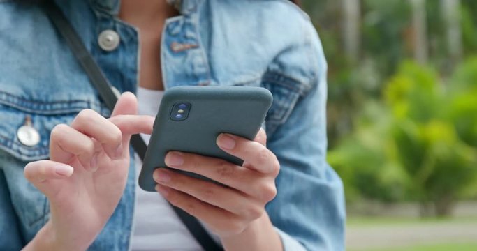 Woman use of mobile phone in city park