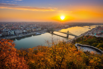 Budapest, Hungary - Panoramic skyline view of Budapest at sunrise with beautiful autumn foliage, Liberty Bridge (Szabadsag Hid) and lookout on Gellert Hill