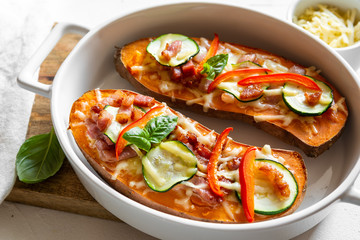 Baked sweet potato with bacon, sour cream, zucchini, red pepper and cheddar cheese.