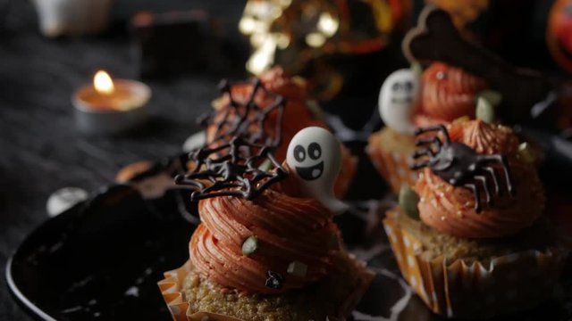 Fancy Halloween food Party Table with Pumpkin Cupcake Muffin and cookies.