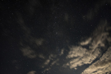 Stars through the clouds in the moonlight on a summer night