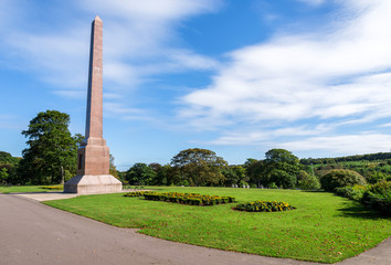 Magnificent McGrigor Obelisk with flower beds in front on a blue sky background, Duthie Park, Aberdeen, Scotland
