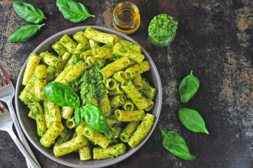 Appetizing pasta with pesto in a bowl on a stylish dark surface