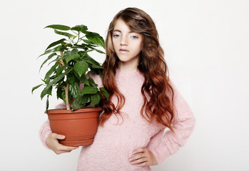 Beauty and fashion concept: Little girl wearing pink outfit and holding flower