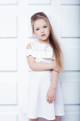 Cute little blond girl wearing white casual clothes on a white background. Fashion style.