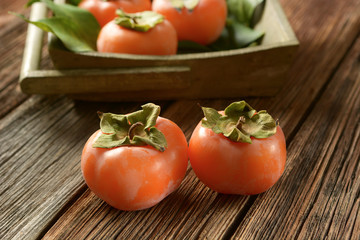 pile of ripe persimmons on wooden table