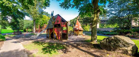 Panoramic view of wooden playground with magic houses and slide in Duthie park, Aberdeen, Scotland