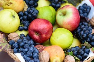 Naklejka na ściany i meble A basket of delicious autumn fruit, grape and apple pear and walnut.