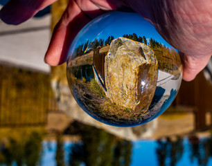 A quarried rock sits at the opening of the fishing peer, while some pine trees rim the hill in the...