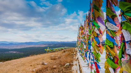Buddhist colored flags on a hill next to a Buddhist monastery