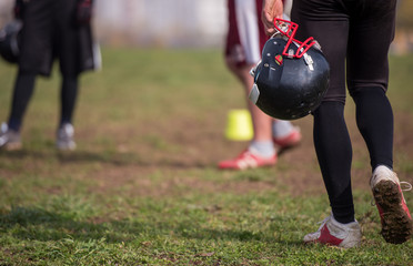 American football player holding helmet