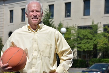Smiling Athlete Senior Male Basketball Coach With Basketball