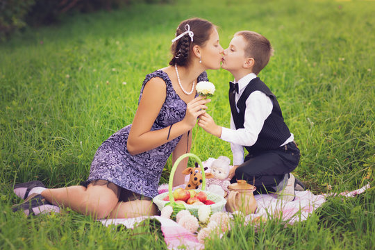 Little boy and teen age girl having picnic outdoors