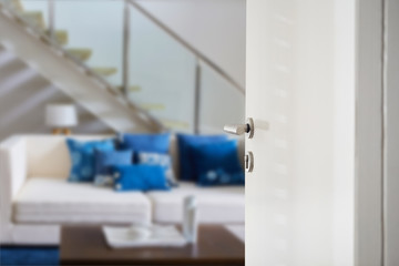 White Door with handle , door open in front of bedroom room blur background, selective focus.