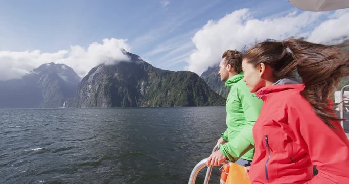 Cruise ship tourists on boat tour in Milford Sound, Fiordland National Park, New Zealand. Happy couple on sightseeing travel on New Zealand South Island. RED EPIC SLOW MOTION.