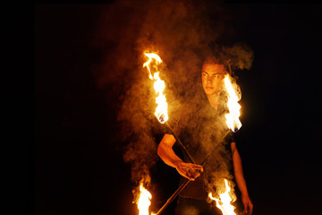 Fire show. Fire dancer juggles with. Night performance. Fire and smoke. Fascinating flame movement. Submission elements of fire.