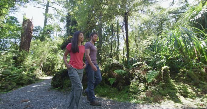 Hiking couple healthy active lifestyle in New Zealand. People hiking in swamp forest nature landscape in Ship Creek on West Coast of New Zealand. Tourist couple sightseeing tramping on New Zealand.